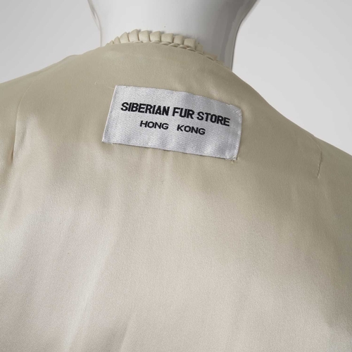 567 - Siberian Fur Store, a three-quarter length azurene mink coat, featuring a lapel collar, hook and eye... 