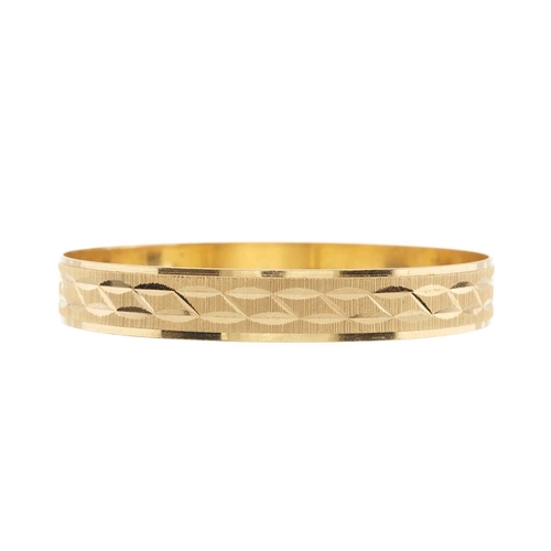 61 - An 18ct gold bangle bracelet, with engraved detail, foreign marks, stamped 750, inner diameter 6.6cm... 