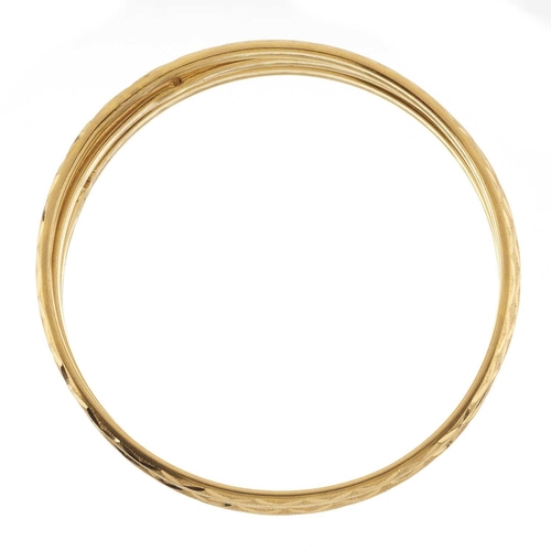 78 - Three high carat gold engraved bangle bracelets, Egyptian marks, inner diameters 6.4cm, 26.2g