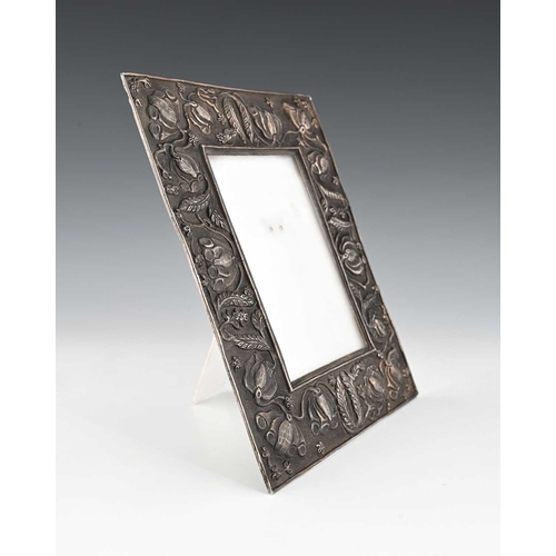 105 - An Arts and Crafts white metal photograph frame, in the 17th century style, embossed in relief and c... 