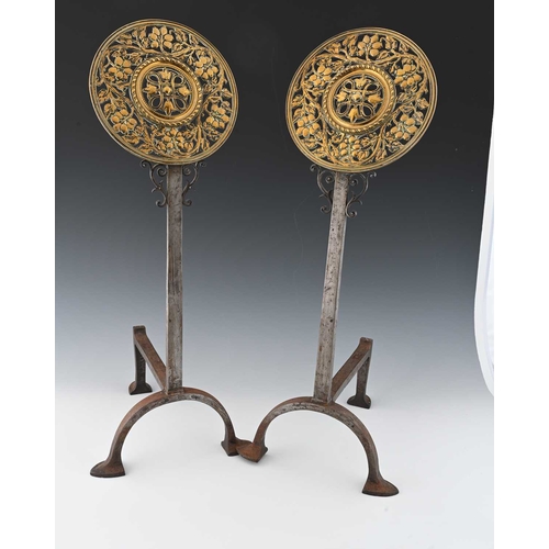 140 - A pair of Arts and Crafts brass and wrought iron fire dogs, circa 1900, the pierced foliate roundels... 