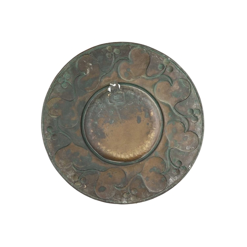 156 - An Arts and Crafts brass broad rimmed charger, circular form planished and repoussé decorated with a... 