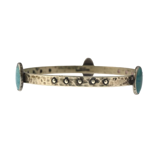 20 - Ruskin, an Arts and Crafts plated metal and cabochon set bangle, planished ring form with bead studs... 