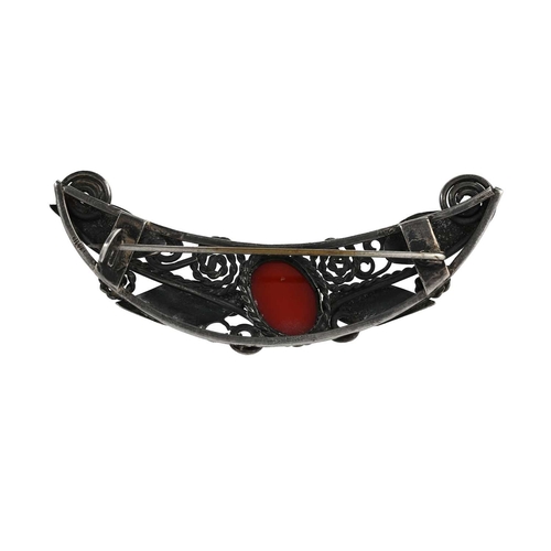 32 - An Arts and Crafts silver and carnelian brooch, in the style of Mary Thew, crescent form, applied wi... 