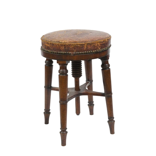 389 - A 19th Century mahogany piano stool, revolving leather studded seat, on four ring turned legs united... 