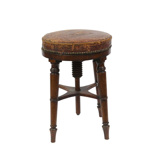 389 - A 19th Century mahogany piano stool, revolving leather studded seat, on four ring turned legs united... 