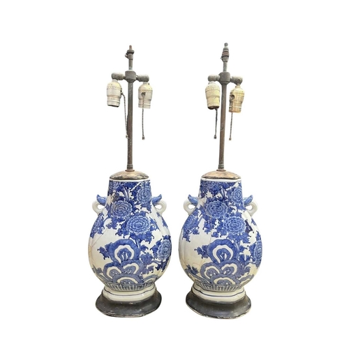82 - A pair of Chinese blue and white porcelain lamp vases, on black wooden bases with brass two light fi... 
