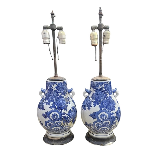 82 - A pair of Chinese blue and white porcelain lamp vases, on black wooden bases with brass two light fi... 