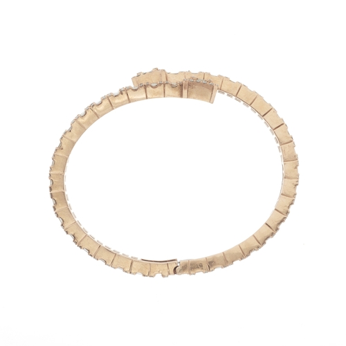 111 - A 9ct gold vari-cut diamond crossover hinged bangle bracelet, estimated total diamond weight 6.50ct,... 