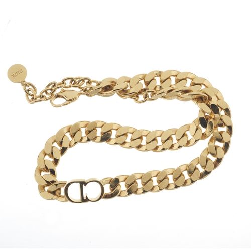 331 - Christian Dior, a gold-tone chain-link choker, with central CD panel, suspending a Dior disc, signed... 