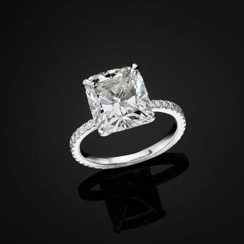 82 - An impressive platinum cushion-shape diamond single-stone ring, with brilliant-cut diamond line shou... 