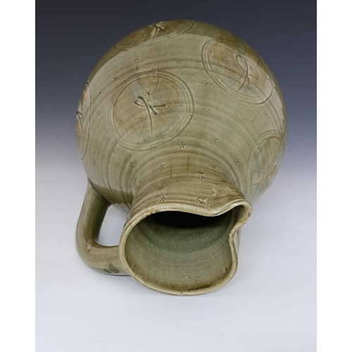 A large studio pottery jug, bulboud form, celadon glazed and decorated ...