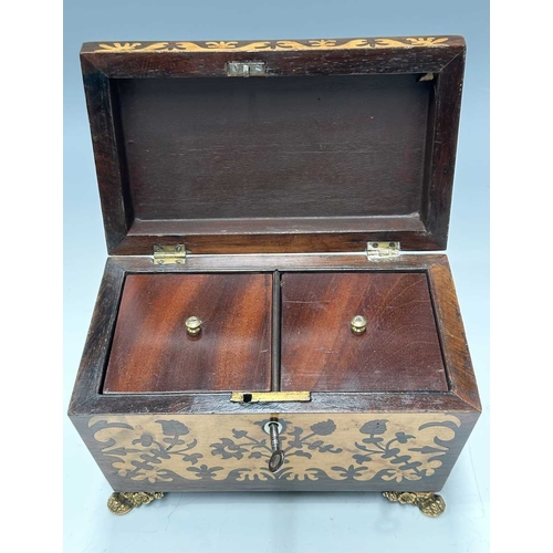 129 - A Regency Inlaid tea caddy of sarcophagus form with marquetry work to the front and top, mounted on ... 