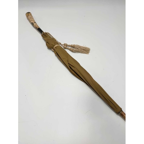 134 - A late 19th early 20th century ladies parasol, carved horn handle and tip, cane shaft with white met... 