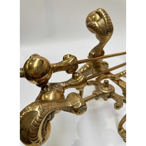143 - A brass companion set and fire dogs, the poker, tongs and shovel all with clawed bird feet holding b... 