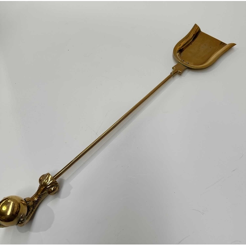 143 - A brass companion set and fire dogs, the poker, tongs and shovel all with clawed bird feet holding b... 