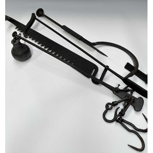 154 - A cast iron butchers hook or steelyard balance scale, length 67cm, together with a wrought iron tram... 