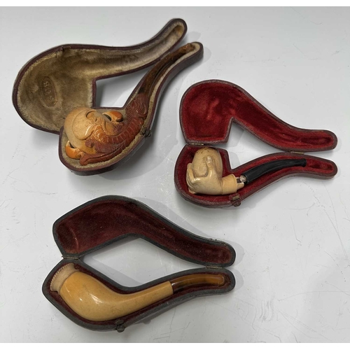 160A - Three Meerschaum pipes, early 20th Century, one a bird of prey talon, one a hand, one bud-shaped, al... 