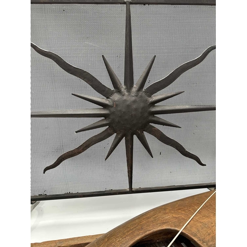 201 - A black painted fire screen, wrought iron frame with central sunburst, scrolled top, height 62cm, wi... 