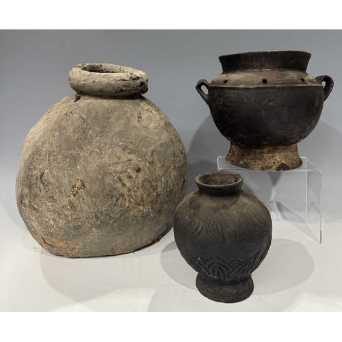 210 - A collection of Tibetan domestic cooking vessels, four teapots with carved wood, metal and earthenwa... 