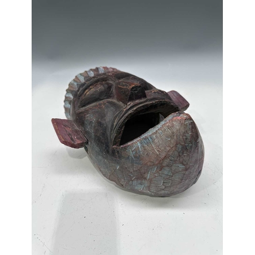 244 - A carved and painted wood dancer's mask, Terai region, Nepal, c.1900, modelled with pointed crown an... 