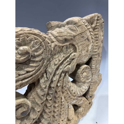 248 - An intricate relief hardwood panel, carved on both sides, modelled as a tiger breathing fire, 19th c... 