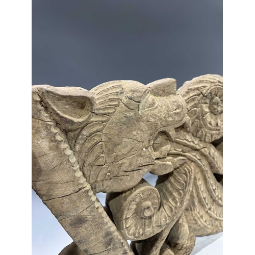 248 - An intricate relief hardwood panel, carved on both sides, modelled as a tiger breathing fire, 19th c... 