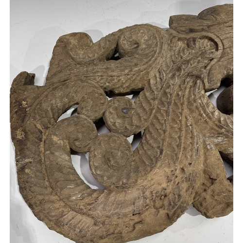 248 - An intricate relief hardwood panel, carved on both sides, modelled as a tiger breathing fire, 19th c... 
