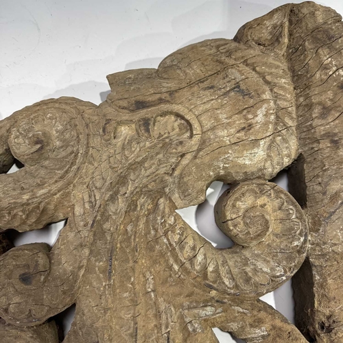 248 - An intricate relief hardwood panel, carved on both sides, modelled as a tiger breathing fire, 19th c... 