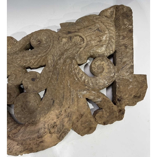 248 - An intricate relief hardwood panel, carved on both sides, modelled as a tiger breathing fire, 19th c... 