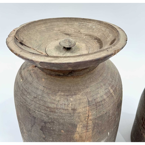 262 - Two Nepalese turned hardwood lidded vessels, cylindrical body with flared rims, designed for the fer... 