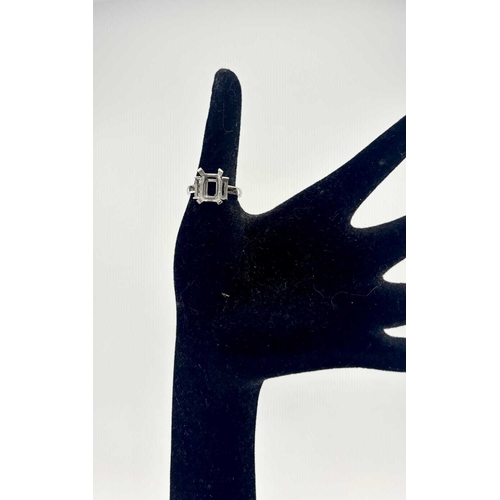 415 - A platinum ring mount, designed for a central rectangular-shape stone flanked by baguette settings a... 