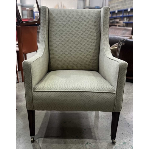 541 - An early 20th century square wingback armchair or easy chair, with sloping arms, on mahogany legs to... 