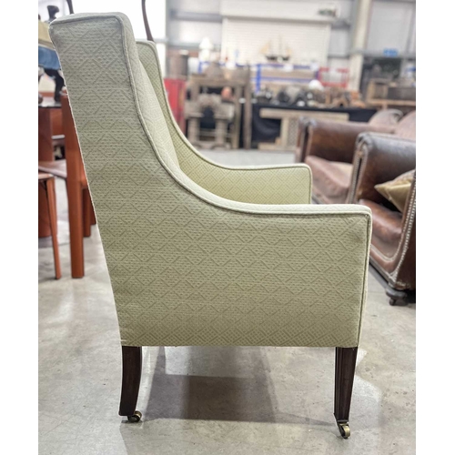 541 - An early 20th century square wingback armchair or easy chair, with sloping arms, on mahogany legs to... 