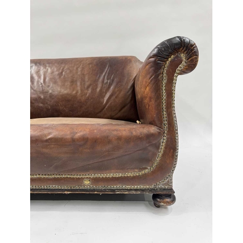 542 - An art deco brown leather three piece suite, low slung and deep seated, lyre shaped arms, with brass... 