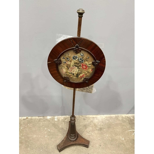 543 - A regency rosewood pole screen, tri-form base on winged feet, rising to a reeded baluster to a taper... 