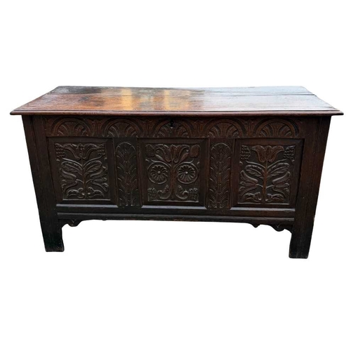 548 - An 18th century panelled, oak coffer or chest with floral and foliate carvings to the three front pa... 