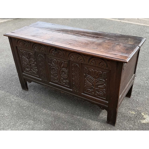 548 - An 18th century panelled, oak coffer or chest with floral and foliate carvings to the three front pa... 