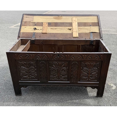 548 - An 18th century panelled, oak coffer or chest with floral and foliate carvings to the three front pa... 