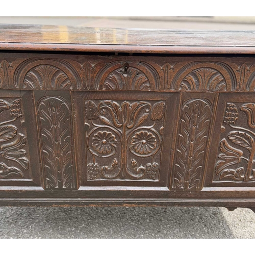 548 - An 18th century panelled, oak coffer or chest with floral and foliate carvings to the three front pa... 