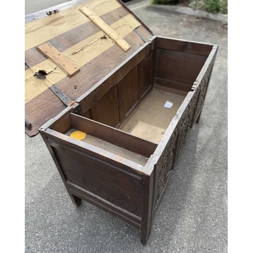 548 - An 18th century panelled, oak coffer or chest with floral and foliate carvings to the three front pa... 