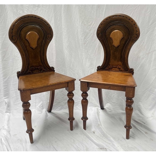 549 - A pair of 19th century light oak hall chairs, lightly carved backs with central blank cartouches, pl... 