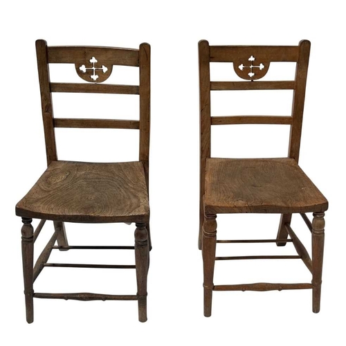 549A - A pair of beech and elm chairs, 19th century, possibly from a church, the top rails carved with cros... 