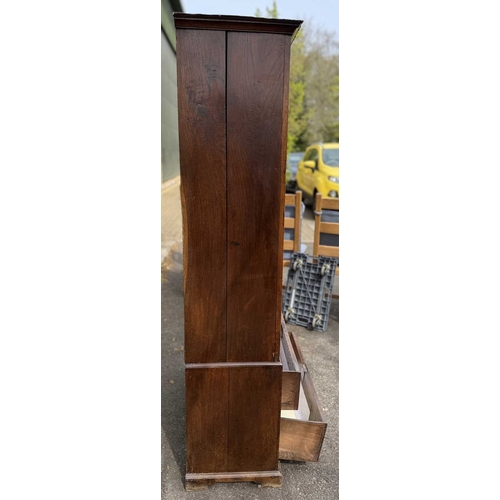 558 - An 18th century oak livery cupboard or linen press arranged as two panelled doors above two drawers ... 