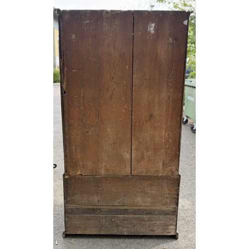 558 - An 18th century oak livery cupboard or linen press arranged as two panelled doors above two drawers ... 