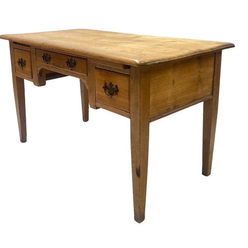 560 - A waxed-pine desk rounded-edge top above a central long drawer with two square drawers either side, ... 