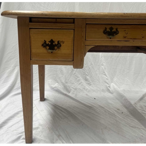 560 - A waxed-pine desk rounded-edge top above a central long drawer with two square drawers either side, ... 