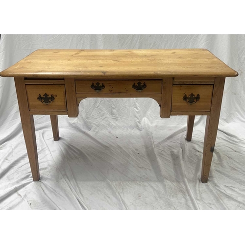 560 - A waxed-pine desk rounded-edge top above a central long drawer with two square drawers either side, ... 