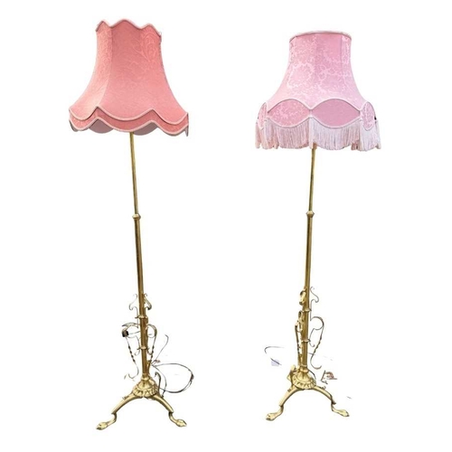 566 - A pair of brass standard lamps in the art nouveau style, telescopic columns down to strapwork and wr... 