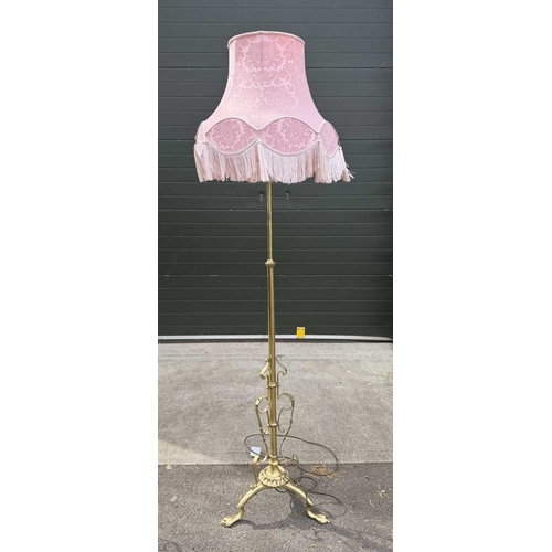 566 - A pair of brass standard lamps in the art nouveau style, telescopic columns down to strapwork and wr... 